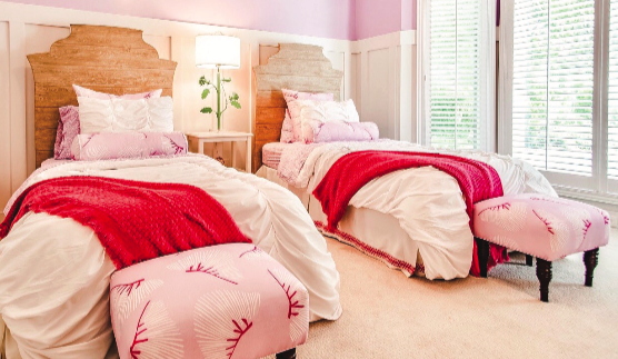 two twin beds with pink and red sheets and quilts