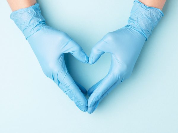 Hands in medical gloves making a heart shape