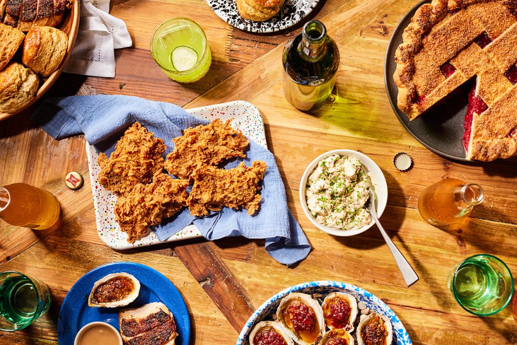 Wooden dinner table with fried chicken, oysters, and pie at Best of Savannah winner Brochu's Family Tradition