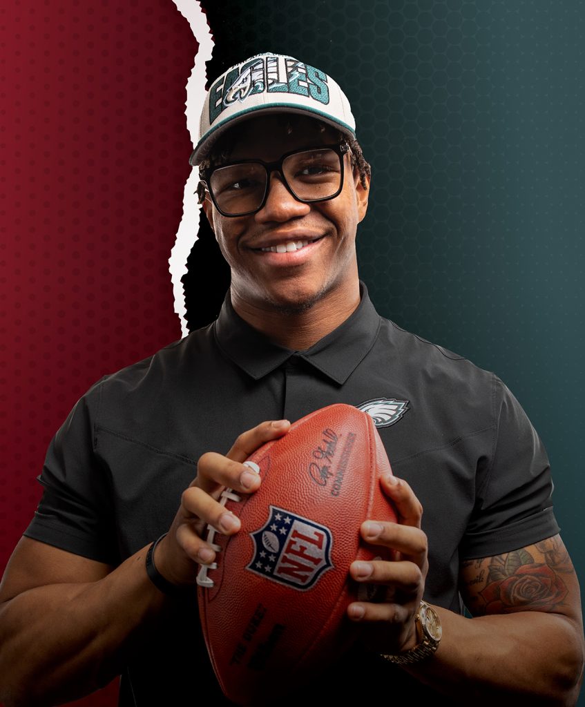 Nolan Smith smiling and holding a football