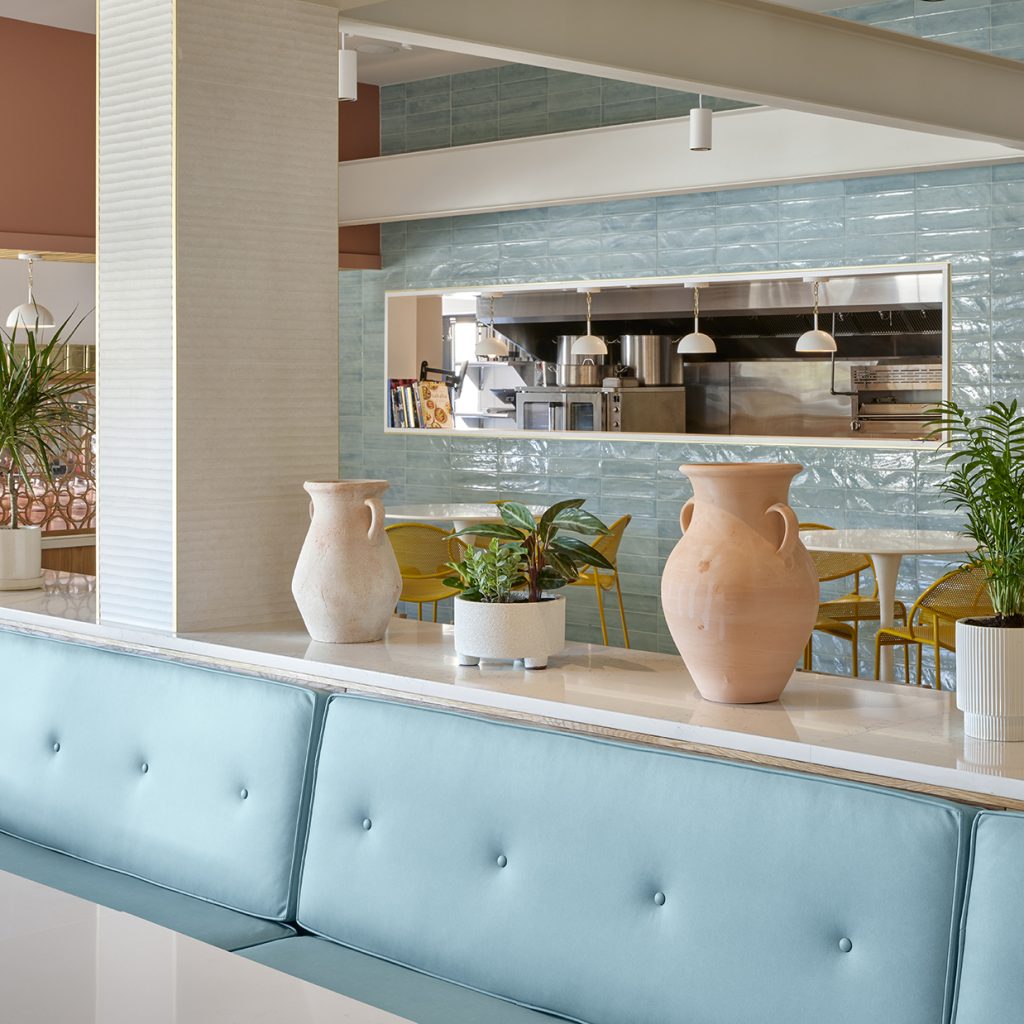 Interior of Best of Savannah Shuk Mediterranean restaurant with blue leather booth seats and light blue tiled walls