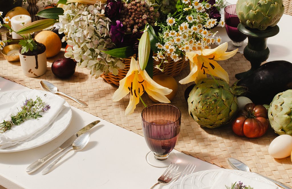 Tablescape with artichokes, fresh eggs and flowers