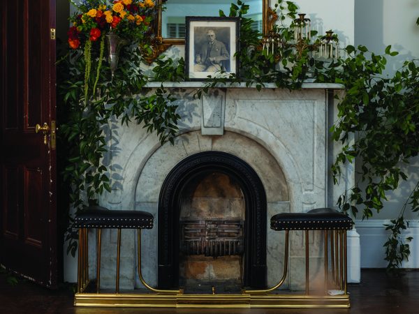 marble fireplace with flowers and foliage on the mantle