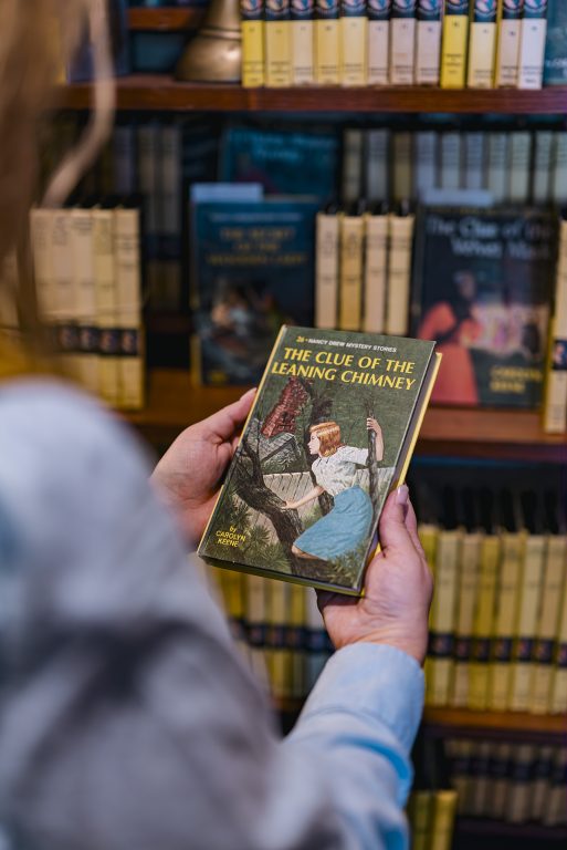 Woman holding a Nancy Drew Mystery book