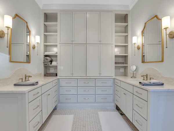 light gray bathroom with floor-to-ceiling storage shelves and cabinets