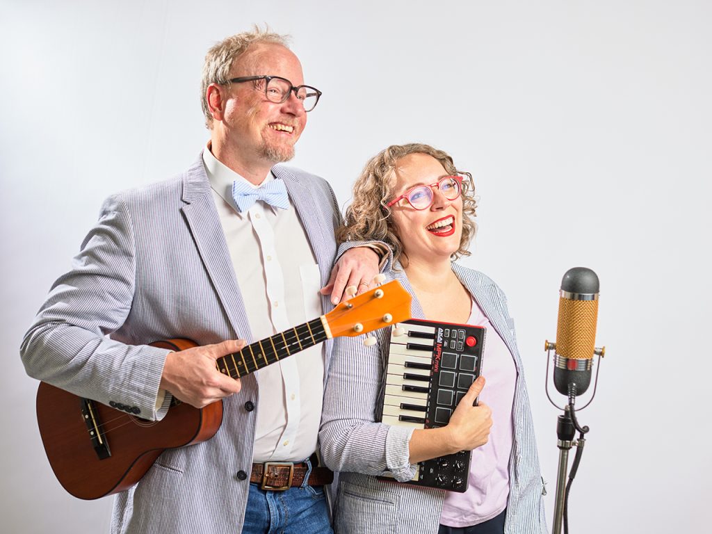 man holding a guitar and woman holding a keyboard