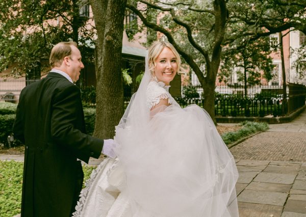 bride and groom walking under a canopy of trees
