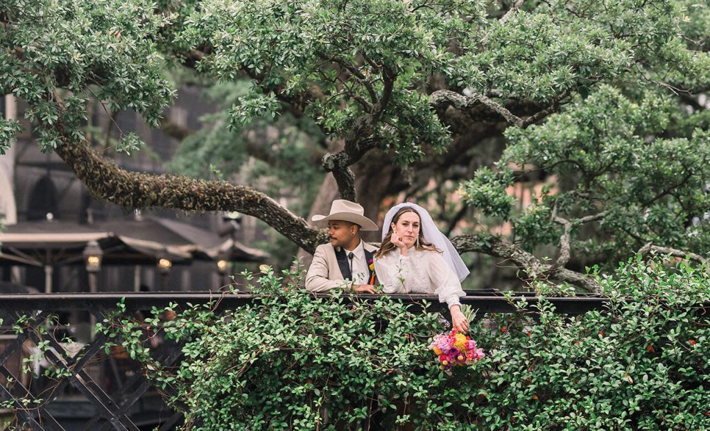 bride & groom standing beneath a live oak