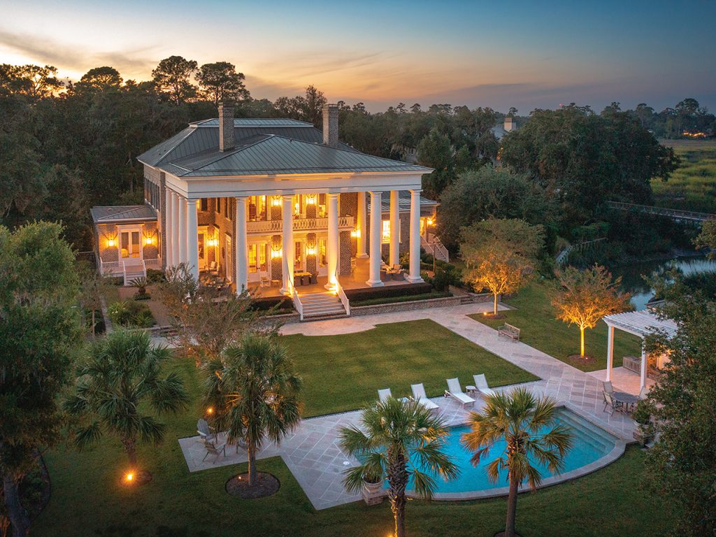 A large house with an in-ground pool and palm trees