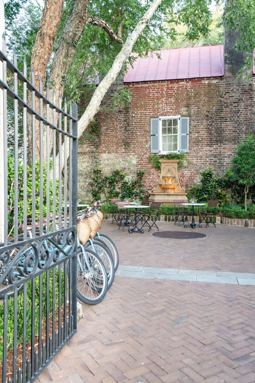 Bikes and cafe tables in a courtyard with herringbone brick patio