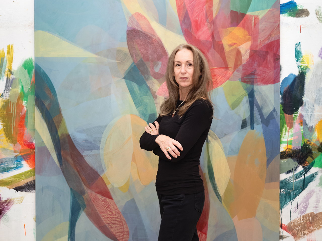 Woman standing in front of a colorful abstract painting