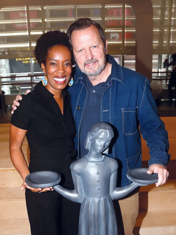 a man and woman standing with the Bird Girl statue replica