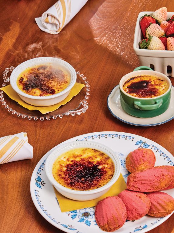 Ramekin's of creme brule, a plate of madelines and a pint of strawberries