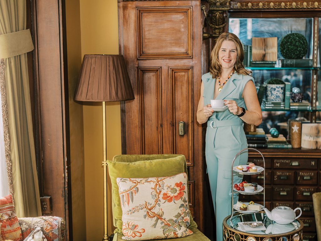 Woman holding a cut pos tea and standing in a luxurious office