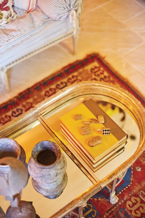 A collection of silver objects on a mirrored coffee table
