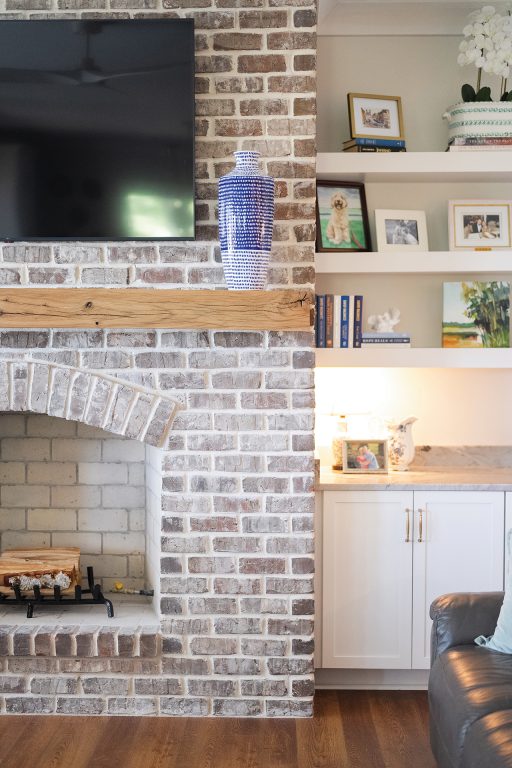 A brick fireplace flanked by builtin bookcases