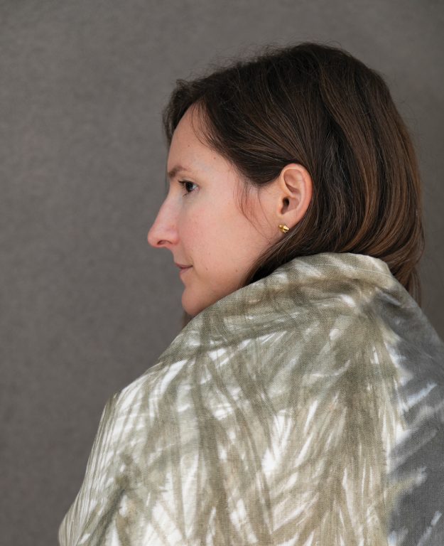 young woman wrapped in a taupe blanket