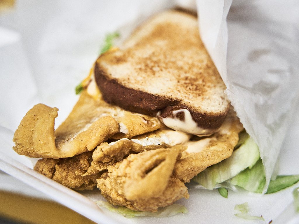 A fried fish sandwich wrapped in paper