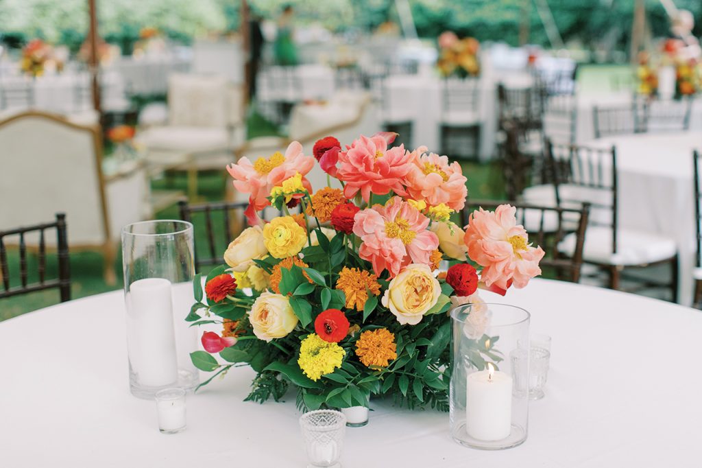 A colorful floral centerpiece on a table with white candles