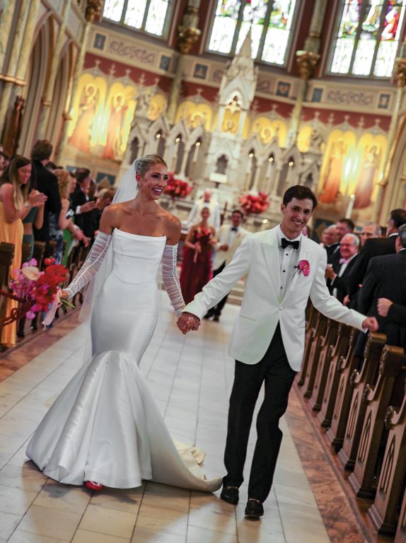A bride and groom walking down the aisle to exit a church