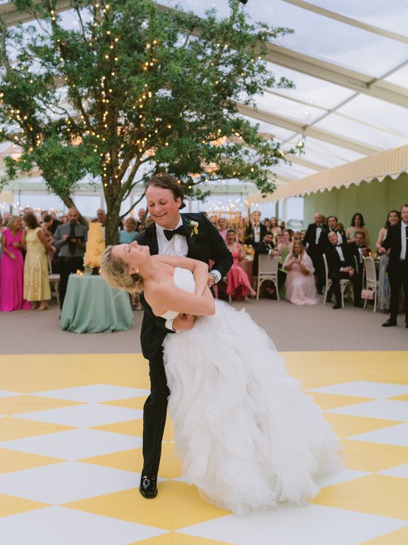 A bride and groom dancing on a white and yellow checkered floor