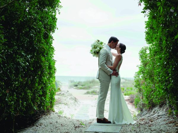 bride and groom kissing on the beach