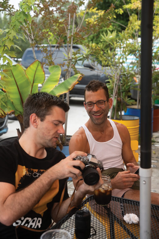 Two men looking at photos on a camera