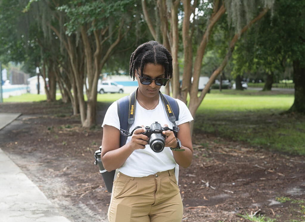 A woman looking in the viewfinder of her camera