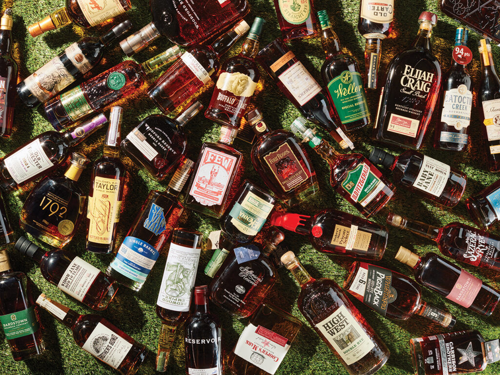 Bottles of bourbon laying haphazardly together on some turf