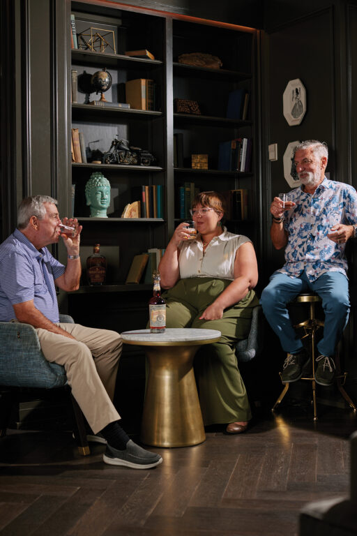 Two men and a woman sipping bourbon