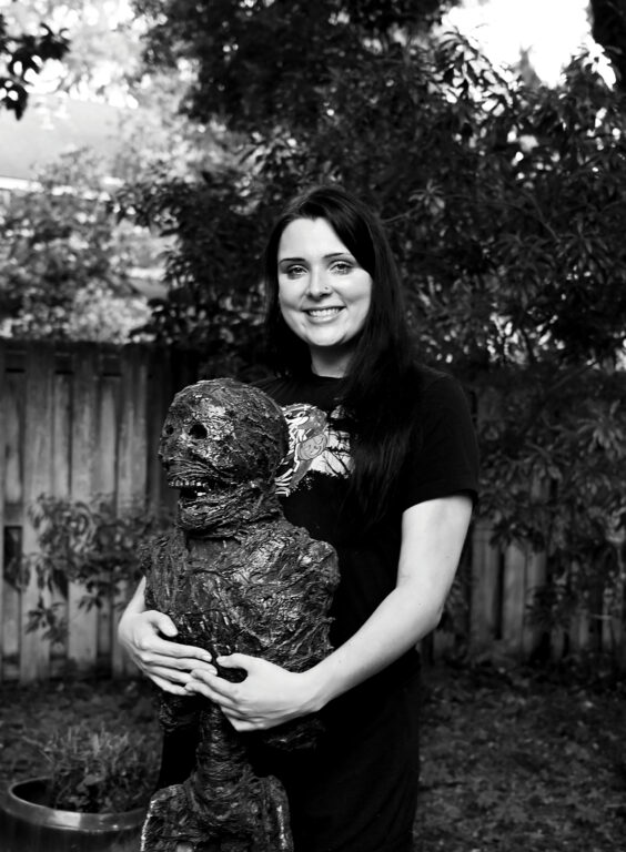 A woman holding a halloween mummy decoration