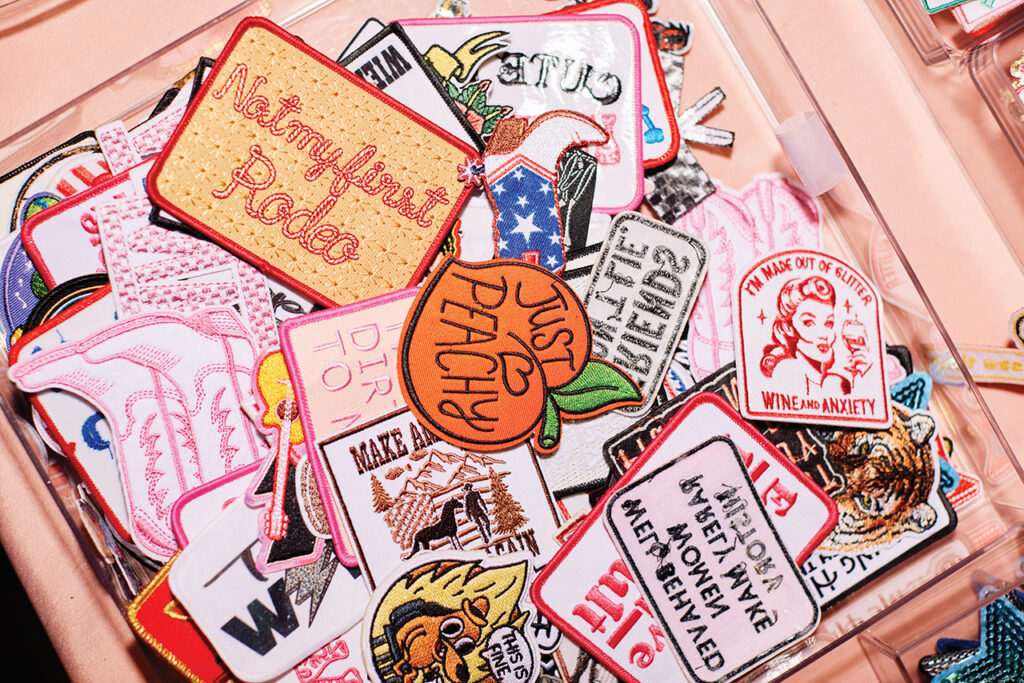 a variety of iron-on patches in a pile