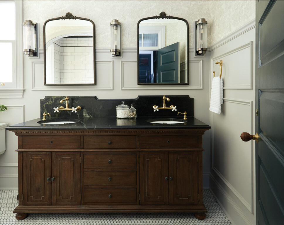 Bathroom with penny tile floor, gray wainscoting, gray cloud wallpaper and double vanity