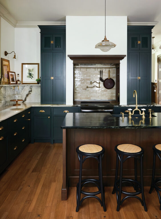 Kitchen with navy blue cabinetry and gold hardware, Portinari marble countertops and a large island with dark soapstone countertop