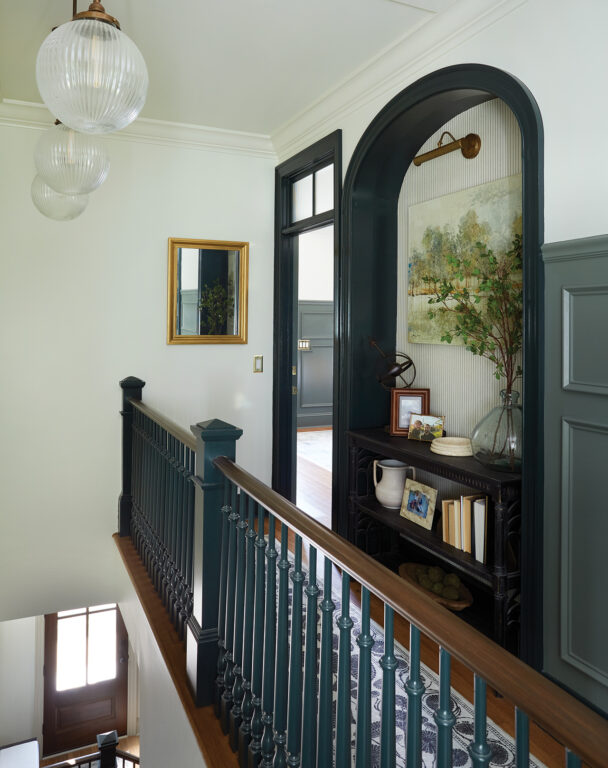 An arched built-in bookcase in an upstairs hallway