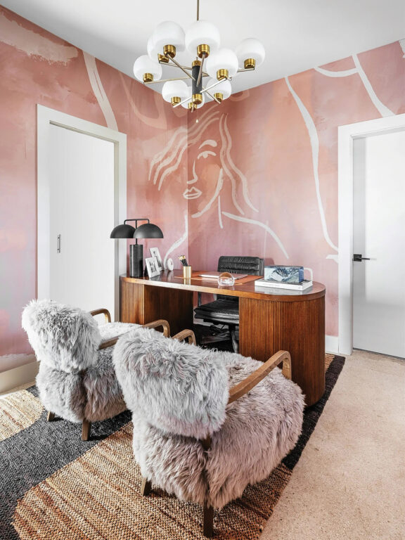 Office with pink walls and fuzzy guest chairs