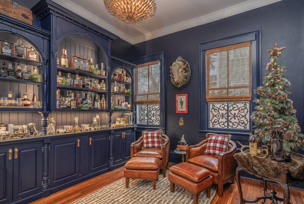 Library with built-in shelves stocked with liquor in a Victorian home decorated for the holidays