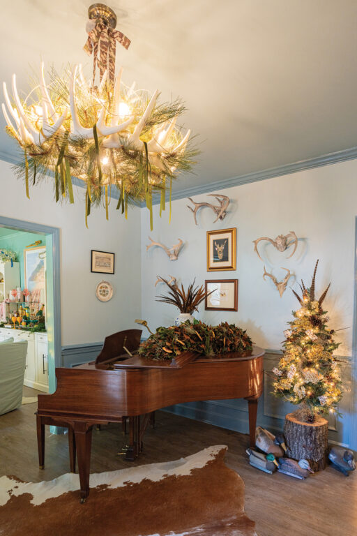 A baby grand piano next to a small Christmas tree