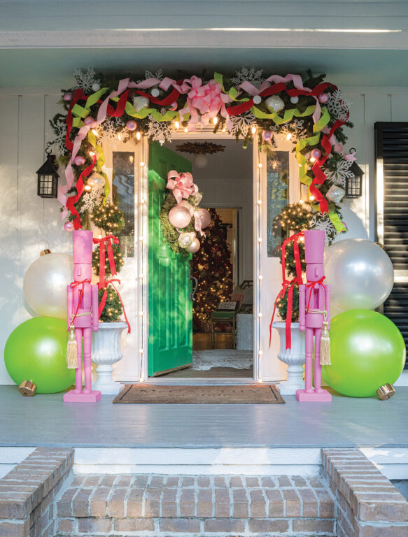 A home's green front door decorated with red, green and pink holiday decorations