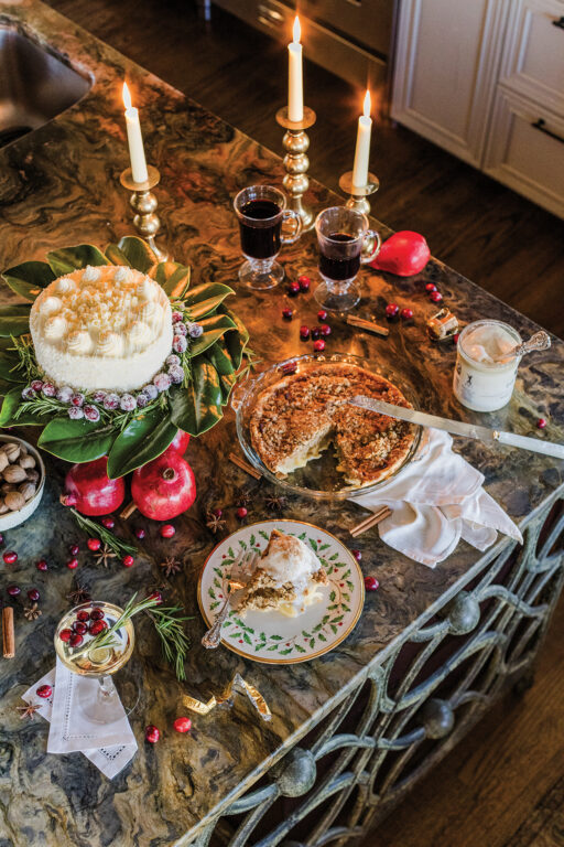 Cakes, pies, candles and glasses of wine and champagne on a kitchen island