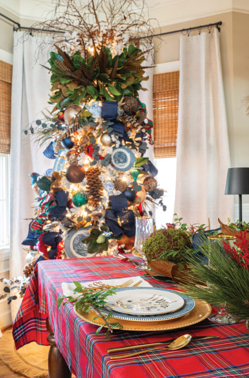 A blue and white Christmas tree decorated with blue plates, navy ribbons, pine cones and fake pheasants