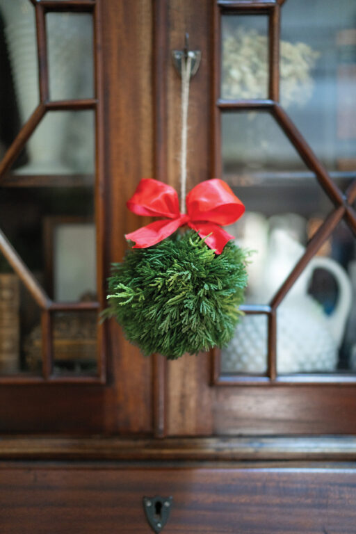 A simple ornament made of a ball of greenery and a red bow