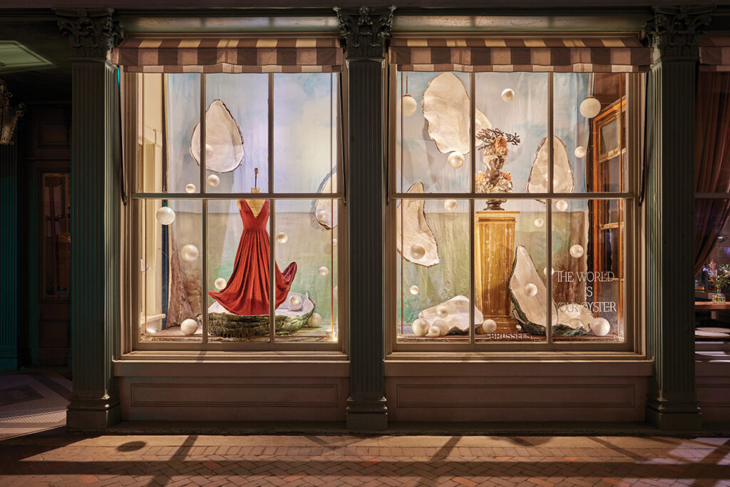 A fanciful window display of oysters and pearls lit up at night