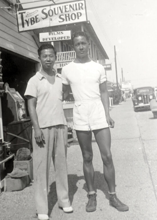 two Asian men standing together on the sidewalk