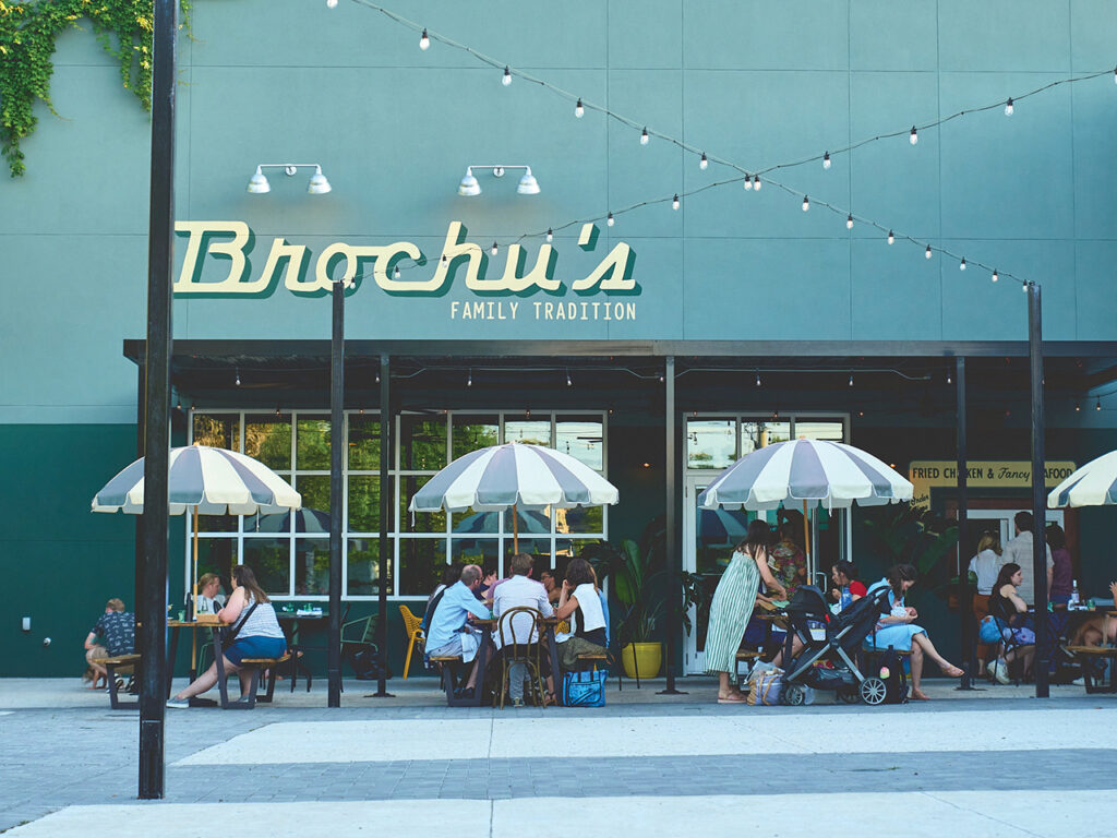 Families eating at picnic tables in front of a cafe