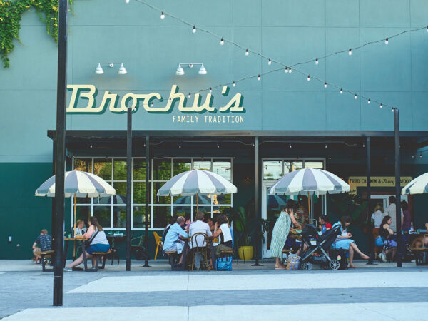 Families eating at picnic tables in front of a cafe