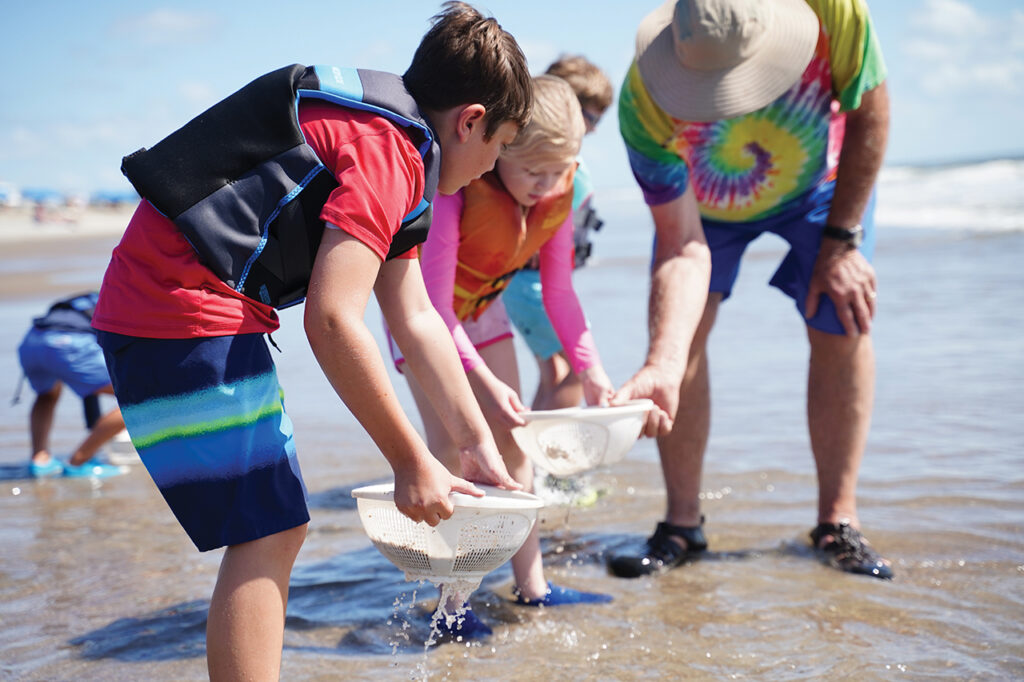 Children sifting sand on a beach