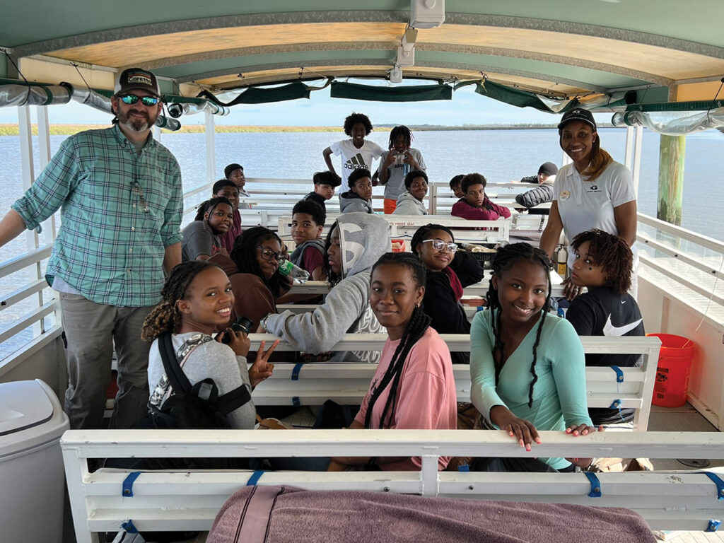 Two teachers and a group of high school students on a boat
