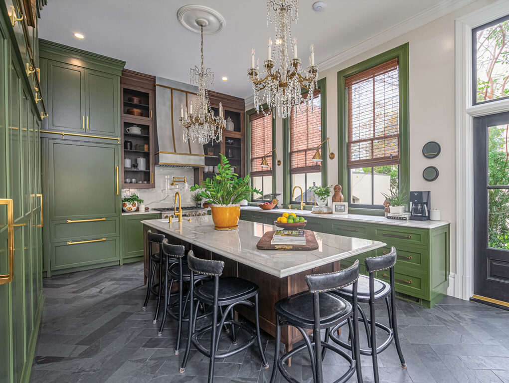 Large modern kitchen in a Victorian home with dark green cabinets, a center island and dark grey tile in a herringbone pattern