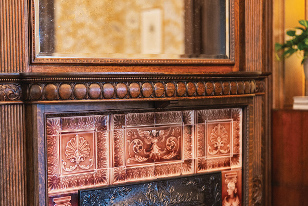 A fireplace with intricately carved wooden mantel and tiles